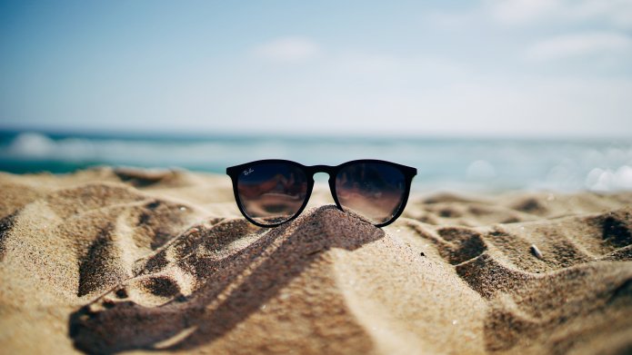 Vakantiefoto zonnebril op het zand met de zee
