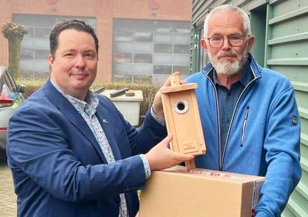 Wethouder Pannekoek geeft gratis nestkastje aan inwoner.