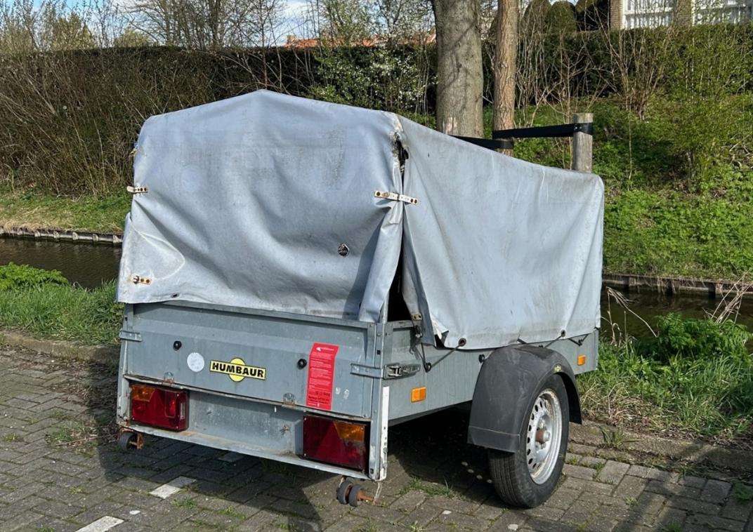 Humbaur-aanhanger met grijs afdekzeil op de parkeerplaats in de straat Het Molenweer in Ammerstol.