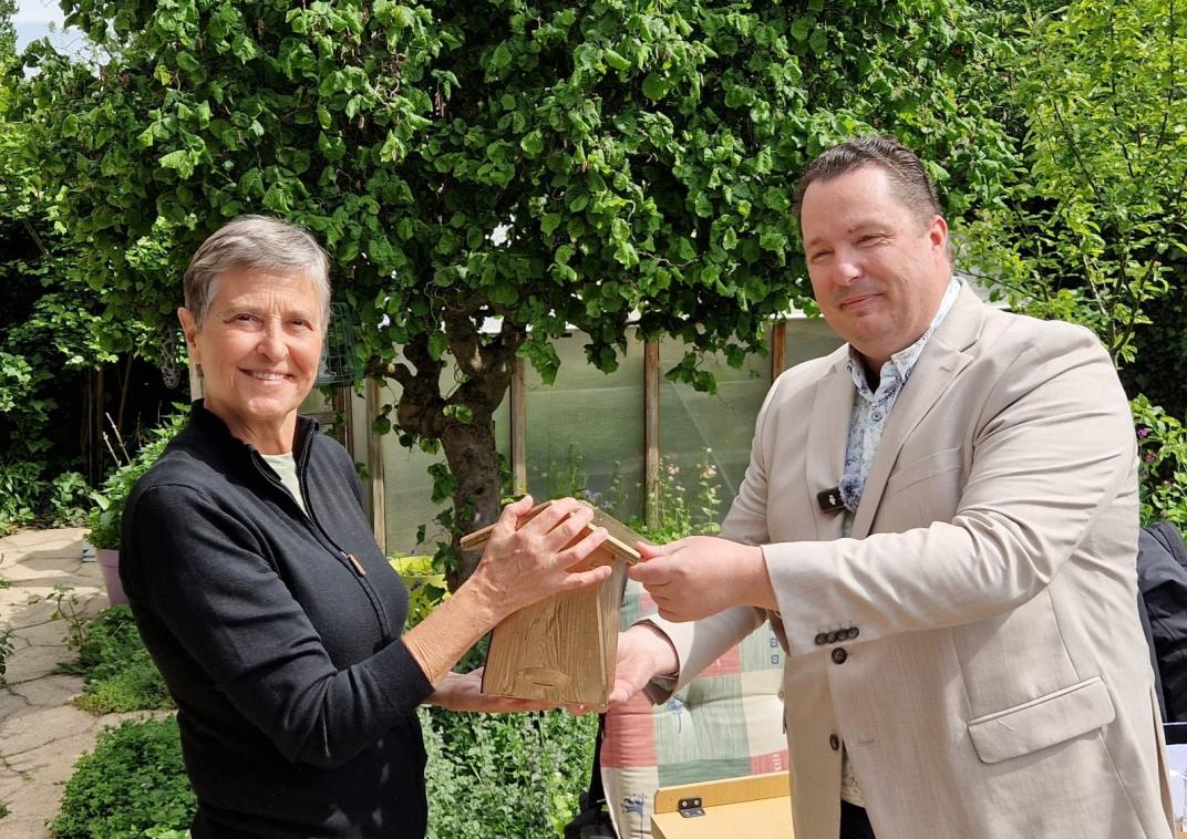 Wethouder Pannekoek overhandigt mevrouw Ziere een gouden nestkastje. 