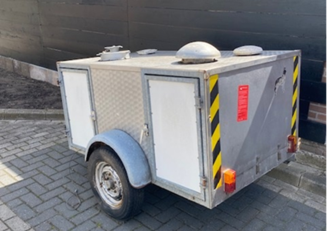 Aanhanger met geel-zwarte stickers op de achterkant.