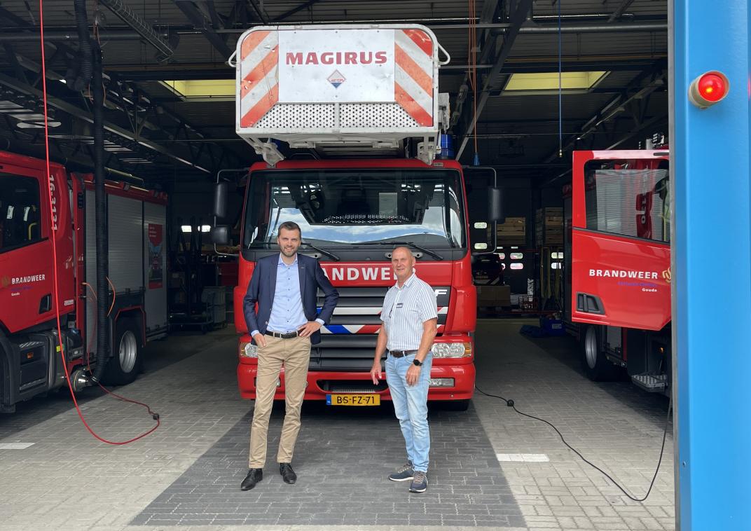 Henk Paaij en Willem Pos voor een brandweervoertuig van VRHM