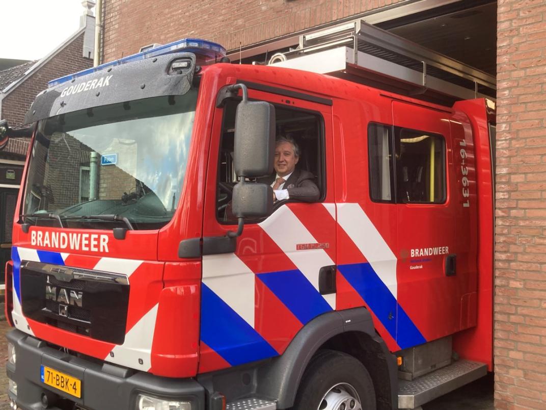 Burgemeester Beenakker in een brandweerauto.
