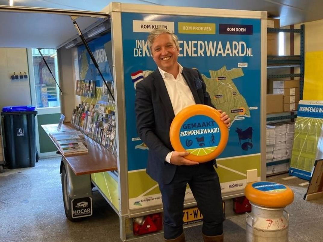 Burgemeester Beenakker in klompen met kaas.