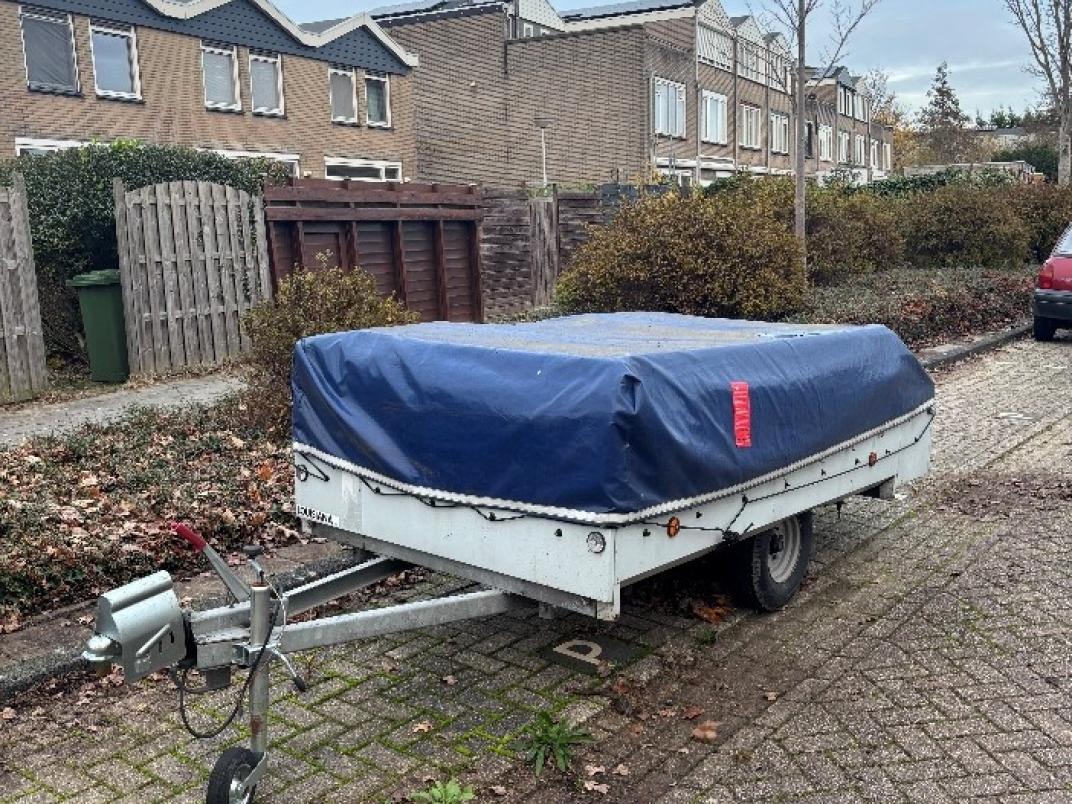 Vouwwagen in Schoonhoven, overdekt met een blauw zeil.