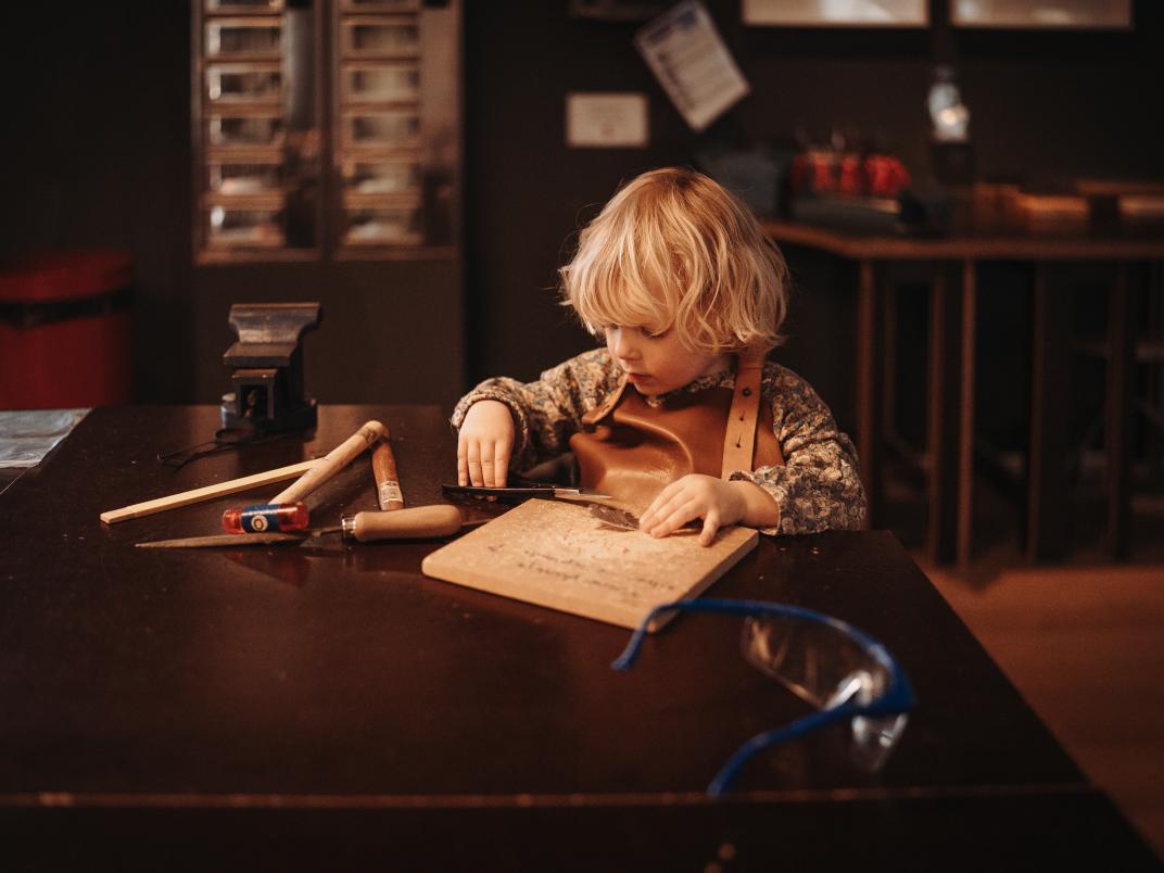 Foto van kind aan werkbank door Anne Herens