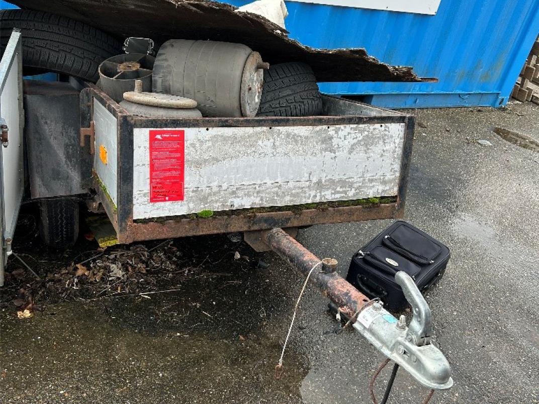 Open aanhanger met lading in Haastrecht met rode sticker op de voorkant.